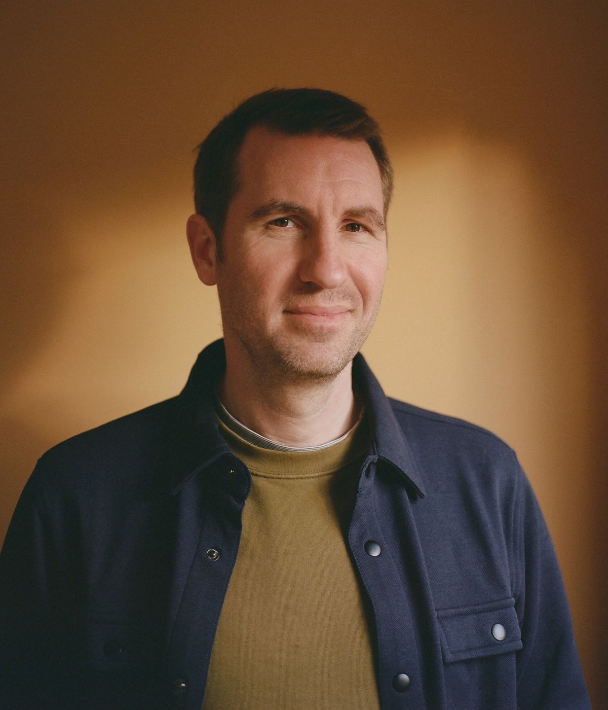 Smiling man in warm light.
